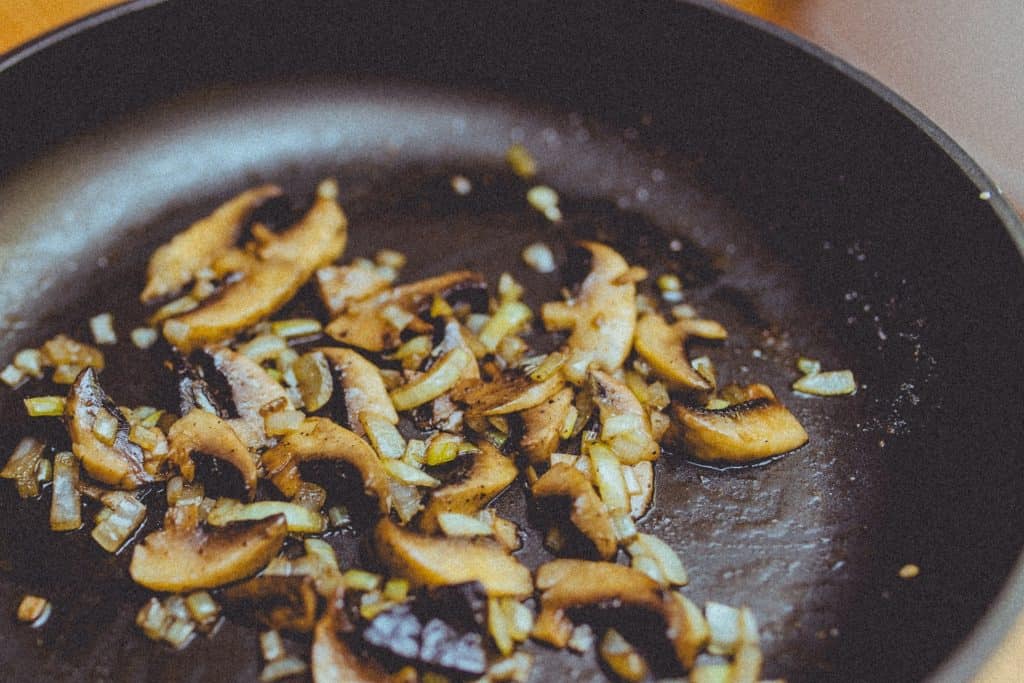 mushrooms cooking in a skillet pan