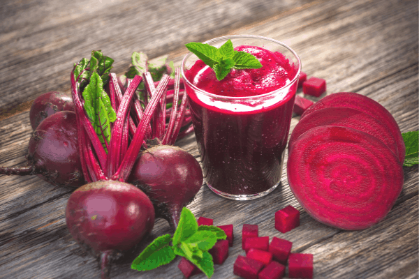 berry beet smoothie - beets on a table around a glass of juice