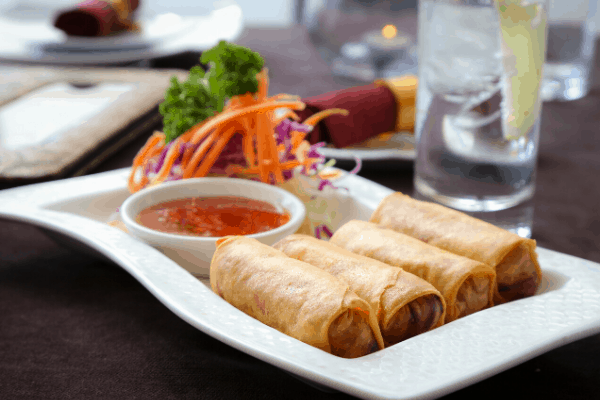 Chinese new year - spring rolls on a plate with sauce and salad