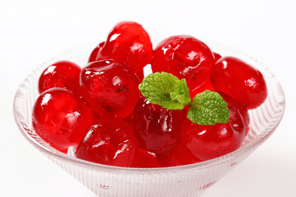 bowl of glace cherries with mint on it