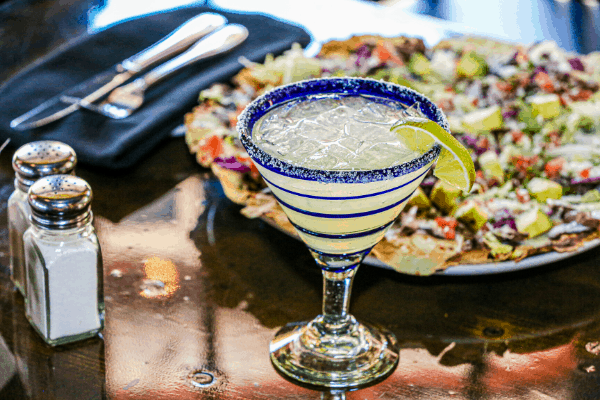 margarita cocktail with plate of food, salt and pepper