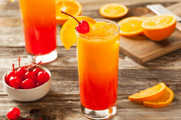 tequila sunrise cocktails with oranges and cocktail cherries