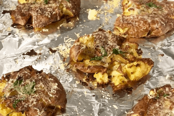 cheesy hot crash potatoes on a tray